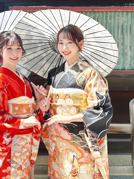 Individuals in traditional kimonos with parasols in Kyoto.