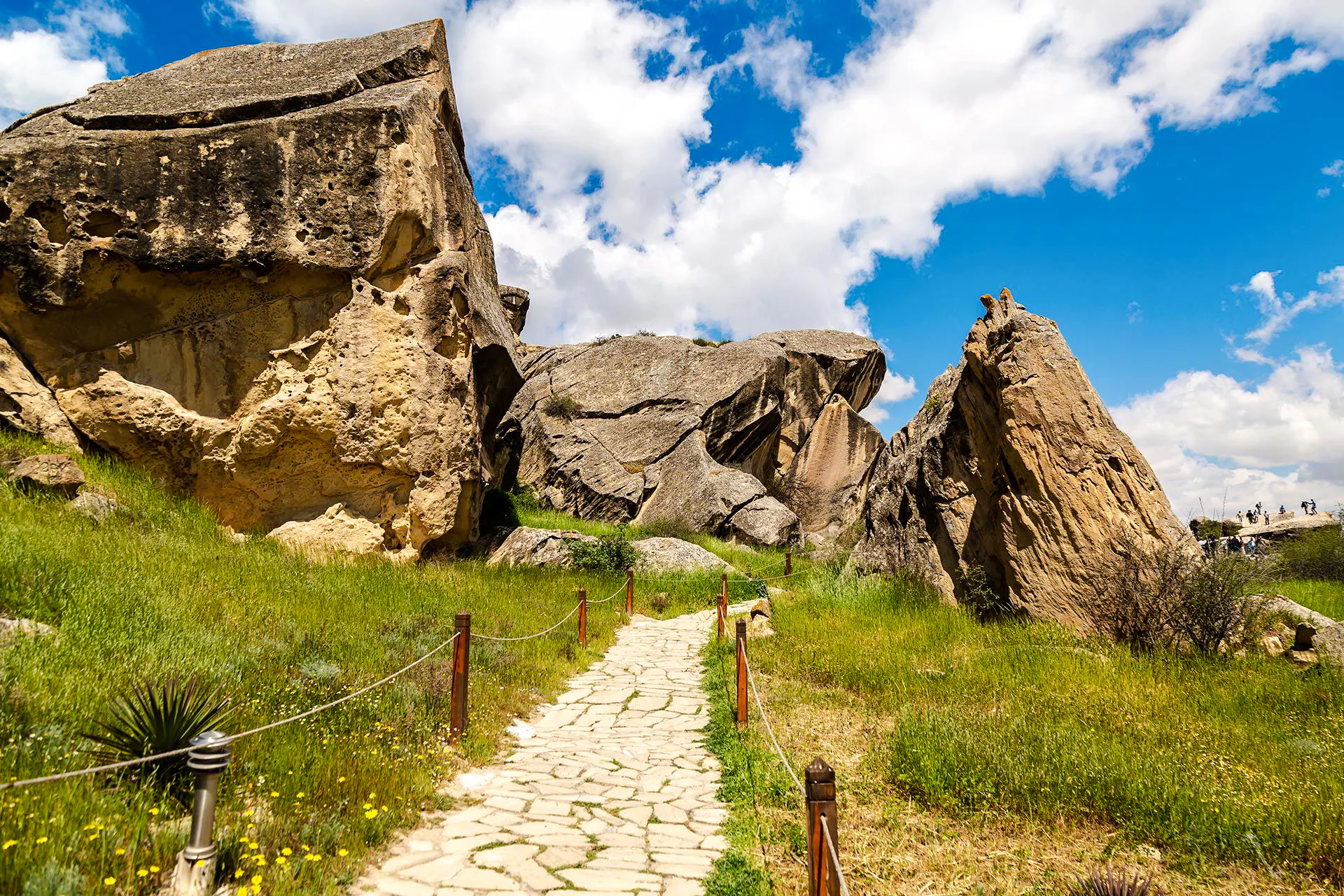 Gobustan rock formations and path under blue sky, Baku tour.