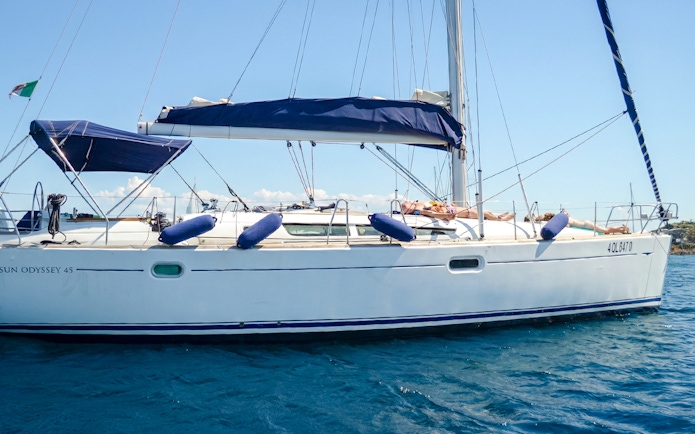 Sailboat excursion in La Maddalena Archipelago with passengers relaxing on deck.