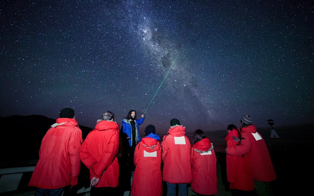 Stargazing group at Mt. John Observatory under a starry sky.