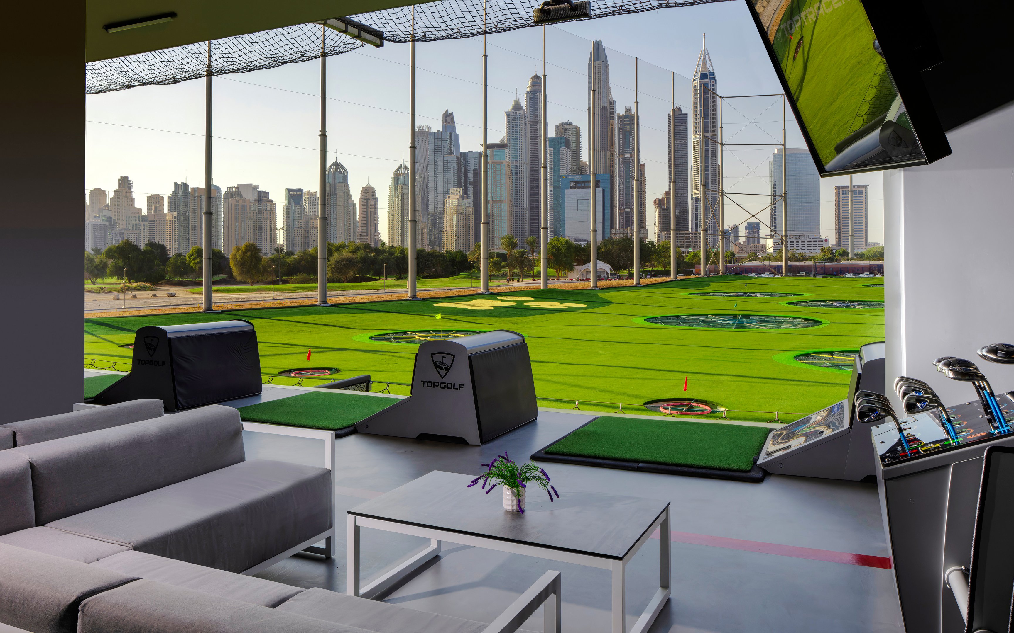 Topgolf Dubai driving range with city skyline in the background.
