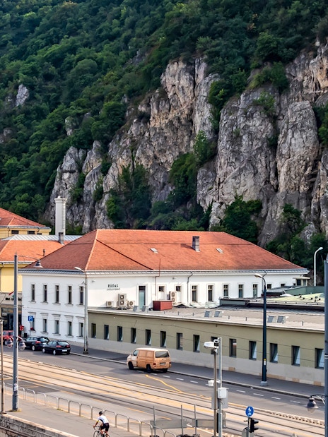 Rudas Thermal Spa building with rocky hillside backdrop in Budapest.