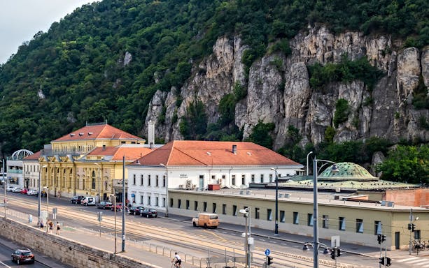 Rudas Thermal Spa building with rocky hillside backdrop in Budapest.