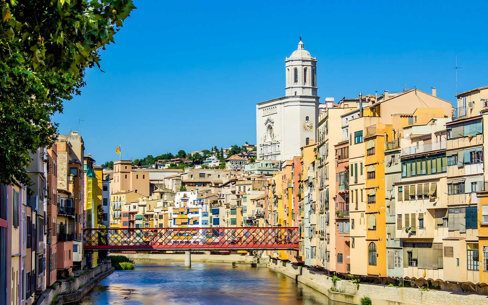 Colorful houses along the Onyar River with Girona Cathedral in the background, Girona, Spain.