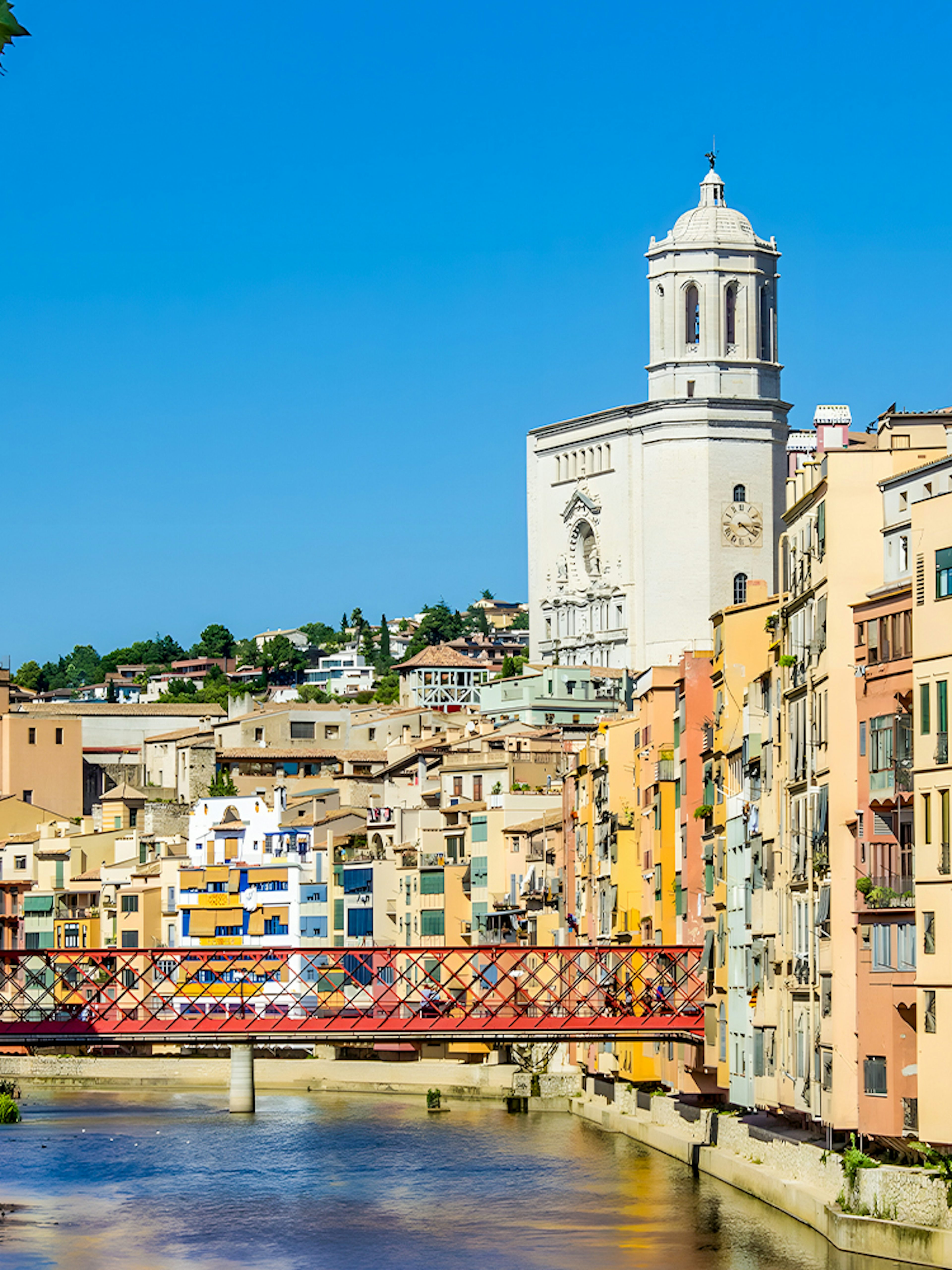Colorful houses along the Onyar River with Girona Cathedral in the background, Girona, Spain.