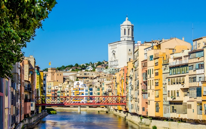 Colorful houses along the Onyar River with Girona Cathedral in the background, Girona, Spain.