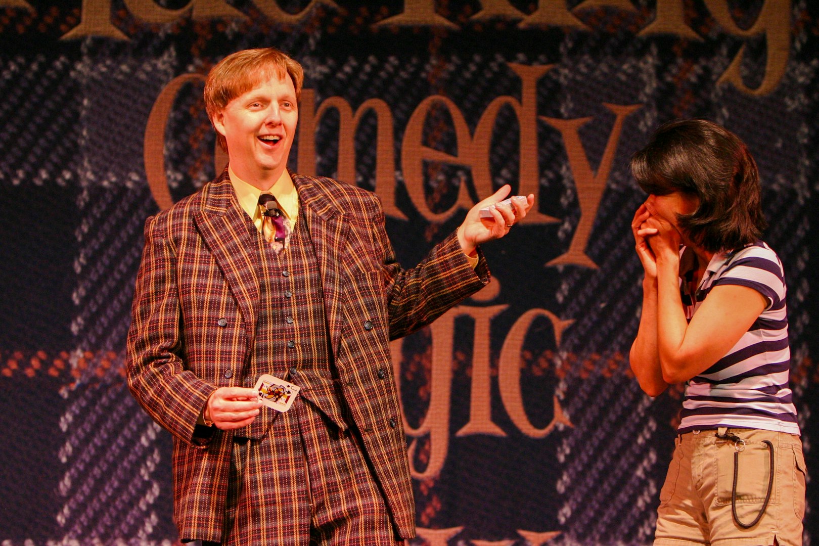 Magician performing card trick with audience member at The Mac King Comedy Magic Show, Vegas.