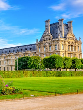 Palace of Versailles gardens with historic building in Paris, France.