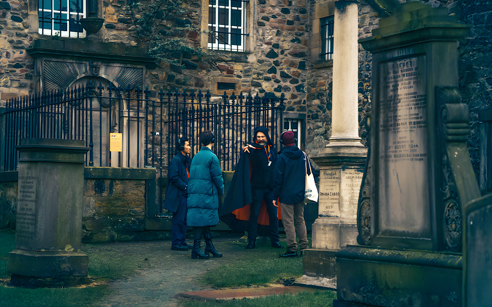 Guide narrating ghost stories to a group in Edinburgh's underground during a ghost tour.