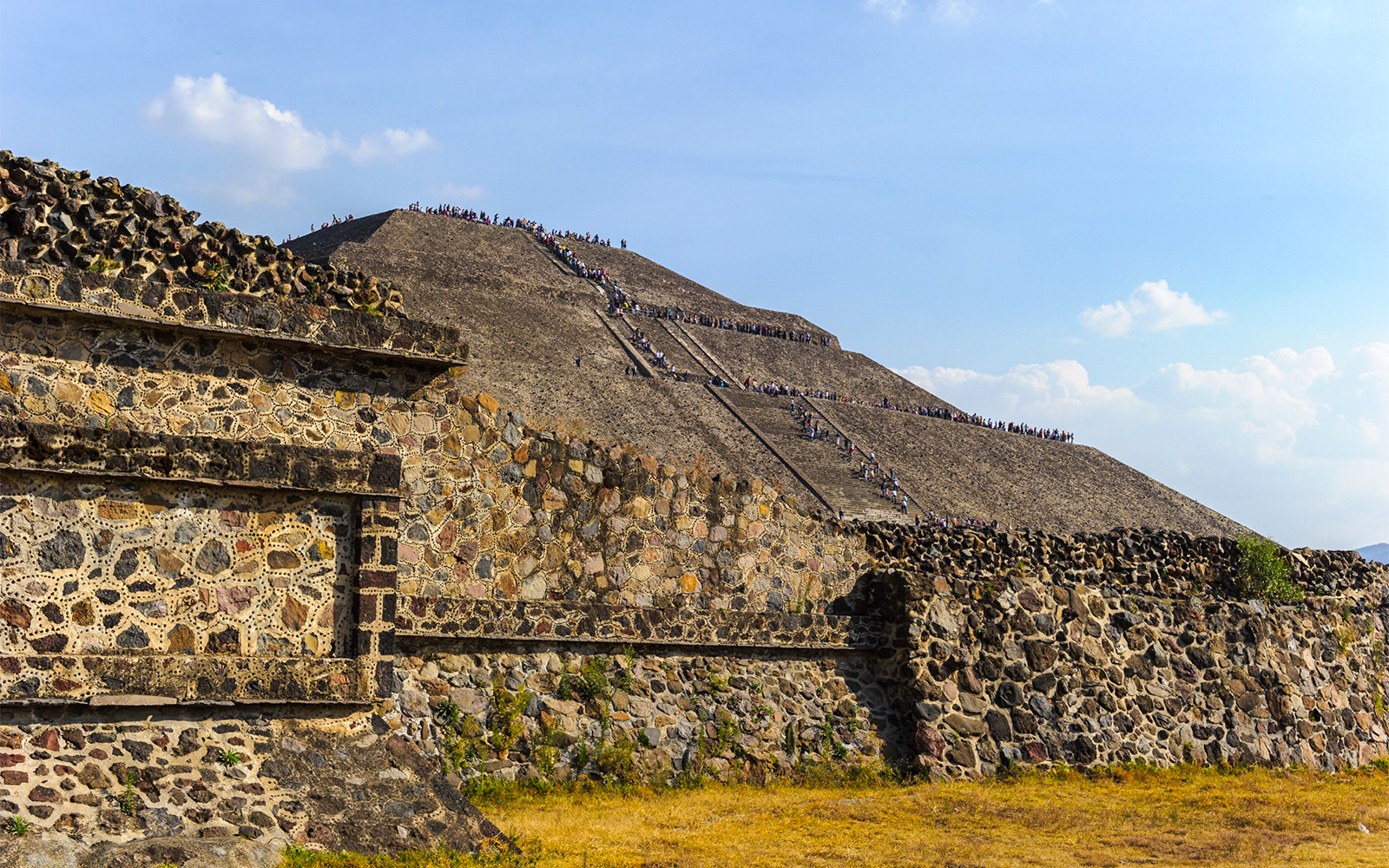 Teotihuacan Pyramid of the Sun with tourists exploring the ancient site in Mexico.