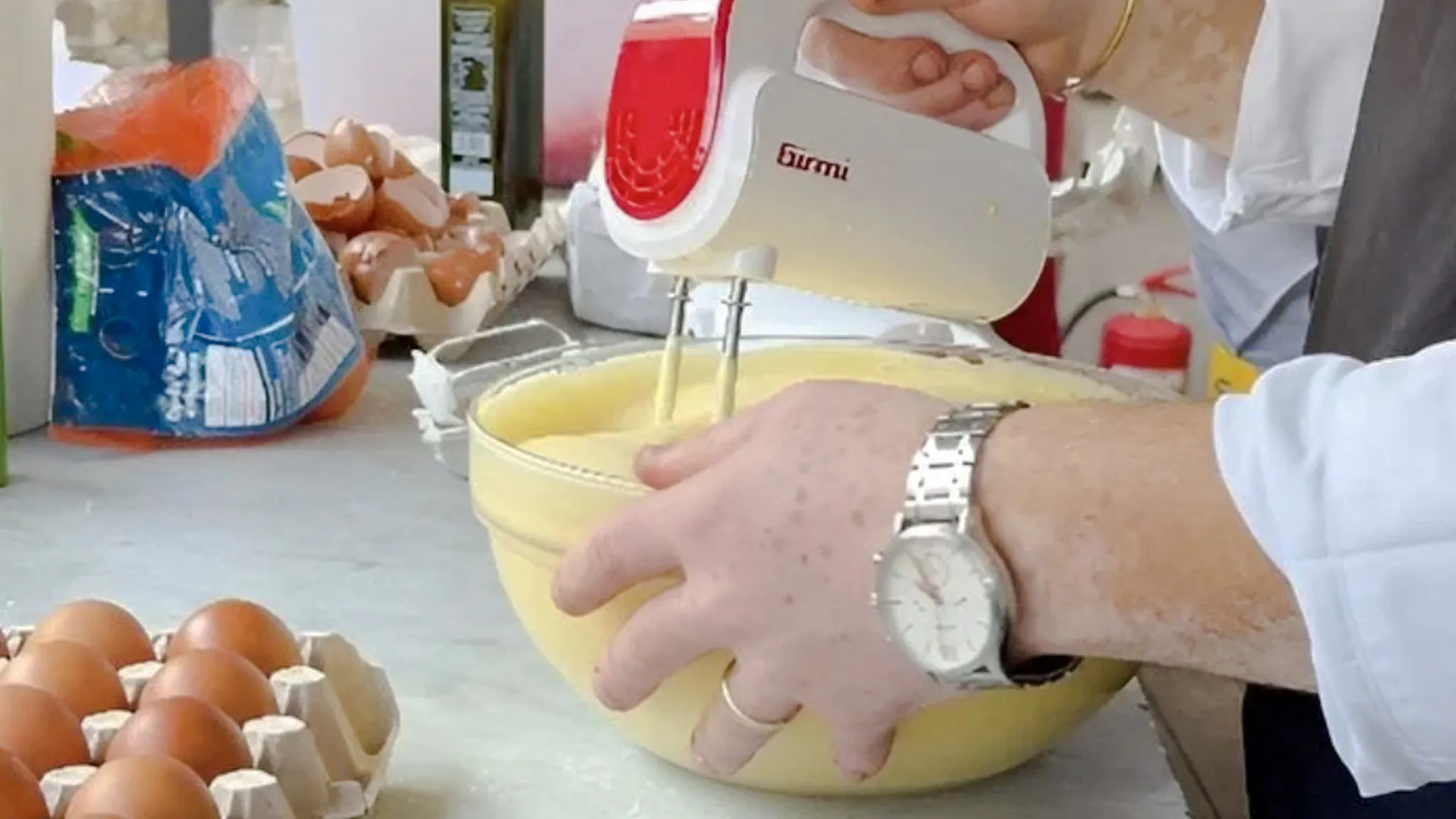 Mixing batter during a pasta and tiramisu cooking class in Rome.