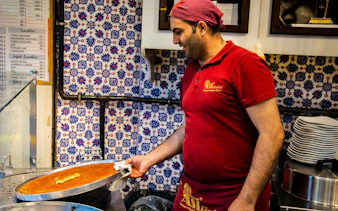 Man preparing traditional Turkish dessert in Istanbul shop.