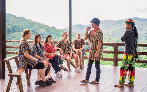 Group learning about elephant conservation at a camp with scenic mountain views.
