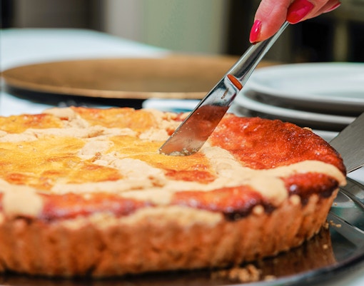 Slicing a homemade Neapolitan pastiera, showcasing its rich texture and traditional Italian dessert appeal.
