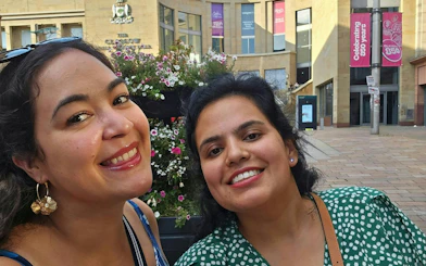 Two people smiling in front of the Glasgow Royal Concert Hall during a city exploration game.