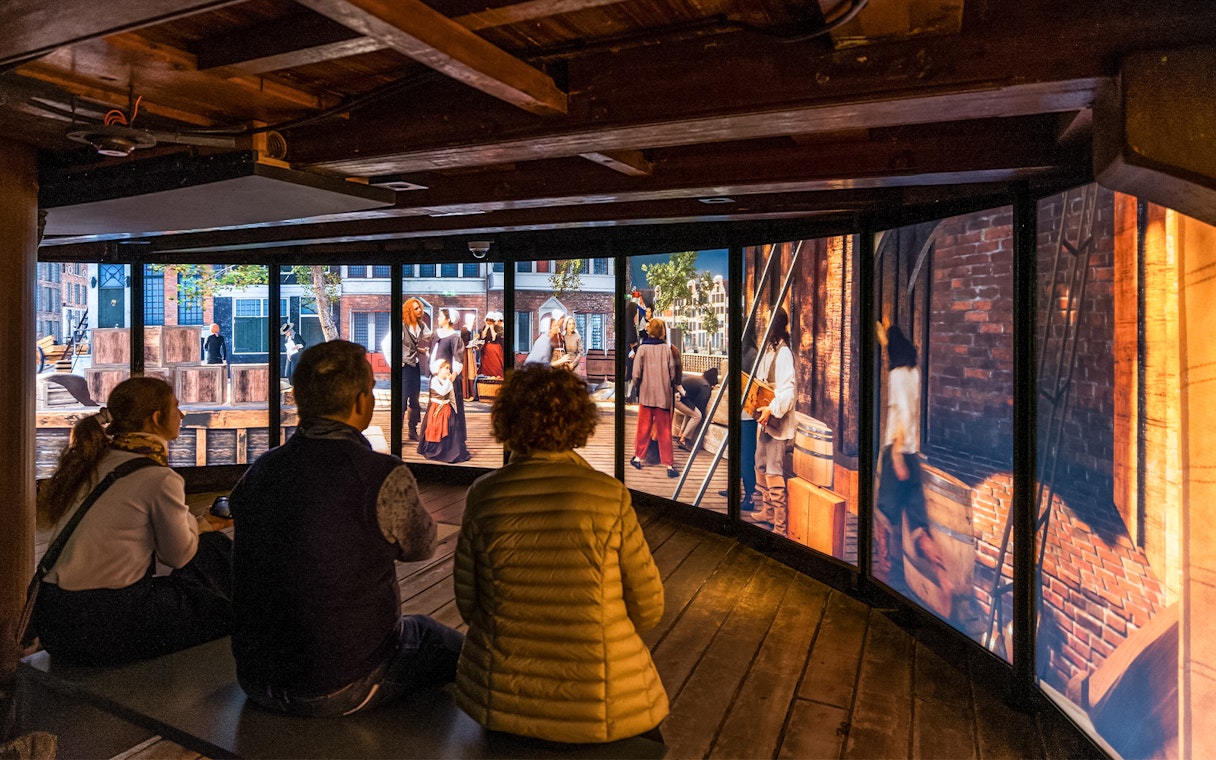 Visitors viewing historical exhibit at The Maritime Museum, Amsterdam.