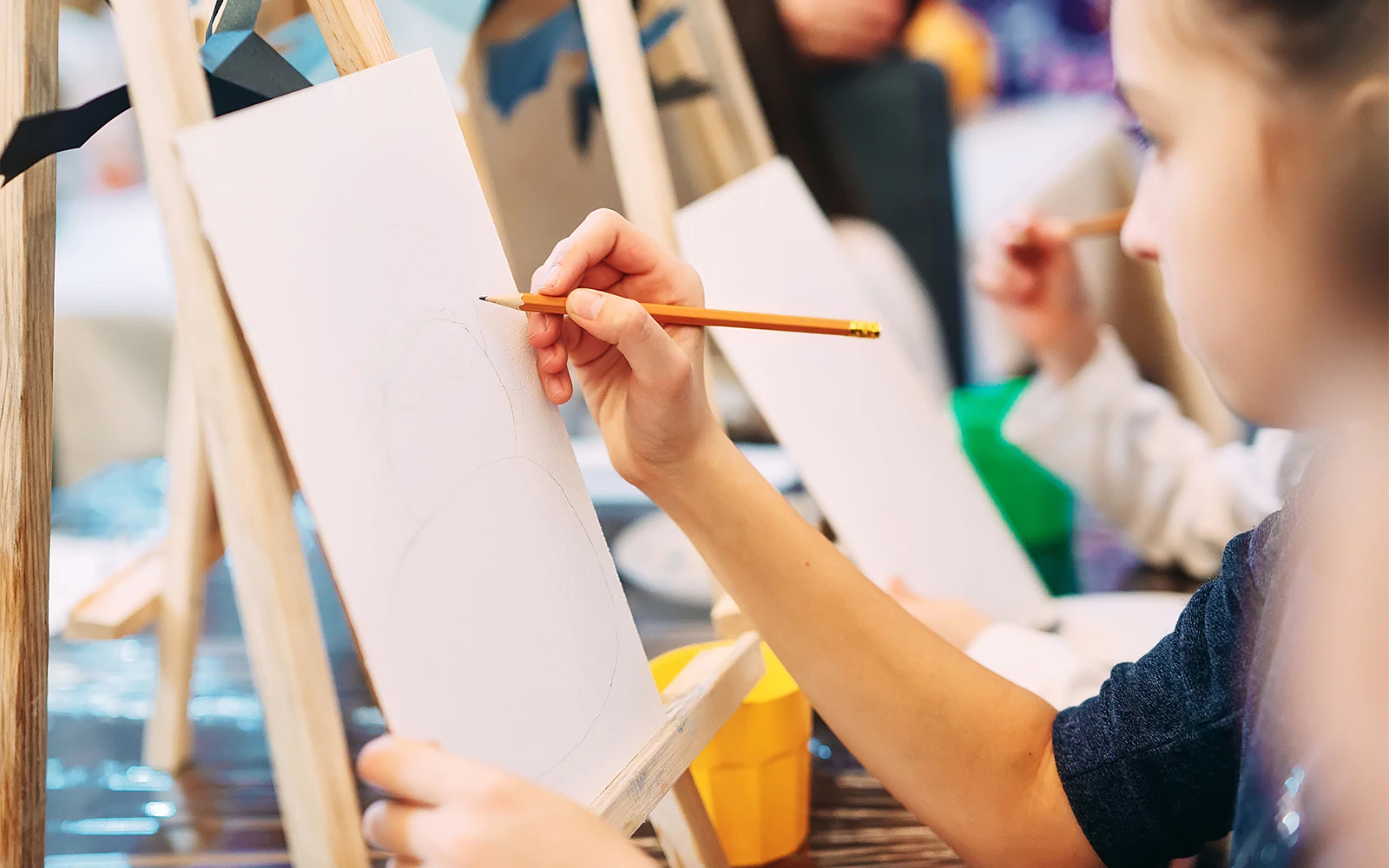 Participants sketching on canvases at a painting workshop.