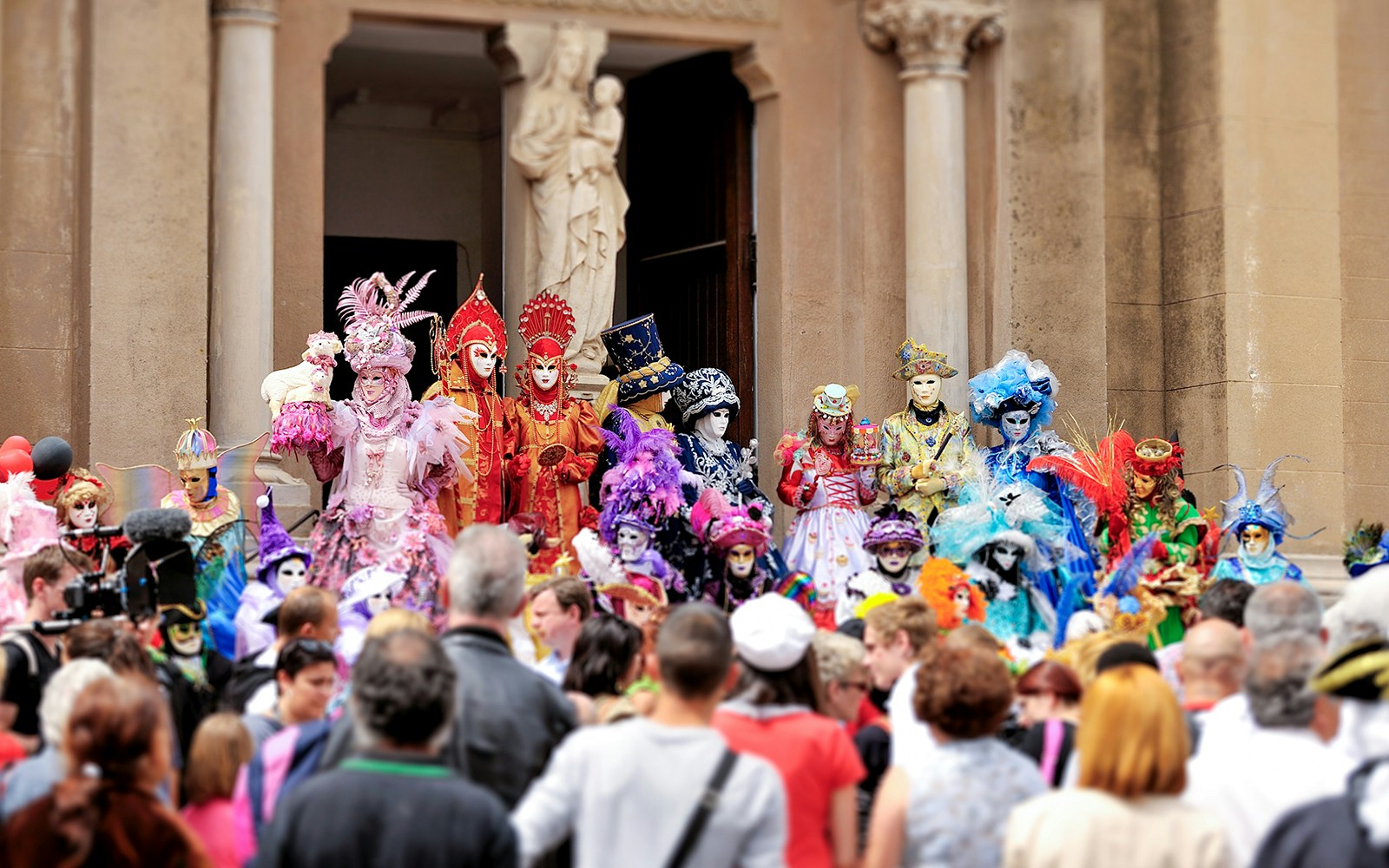 Participants in traditional masks and costumes at Venice Carnival, Italy.