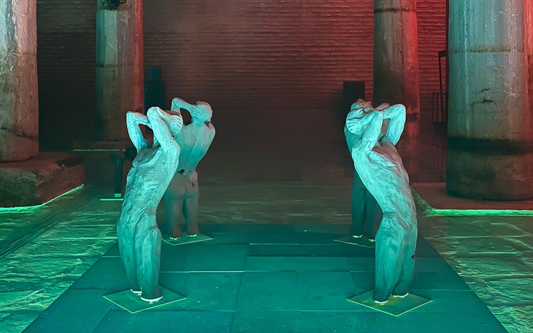 Sculptures inside Basilica Cistern, Istanbul, with illuminated columns.