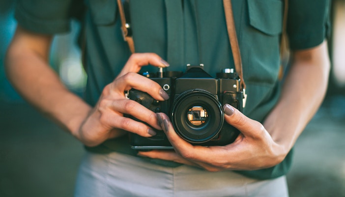 Tourist capturing the Eiffel Tower in Paris, France, with a camera, photography allowed.