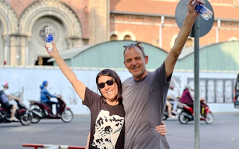 Tourists enjoying a walking tour in front of a historic building in Saigon, Ho Chi Minh City.
