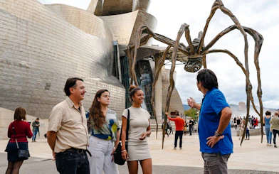 Visitors at Guggenheim Museum Bilbao with Louise Bourgeois' spider sculpture.
