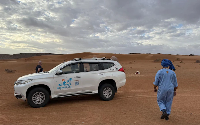 4x4 vehicle in Agadir Sahara Desert with guide in traditional attire.