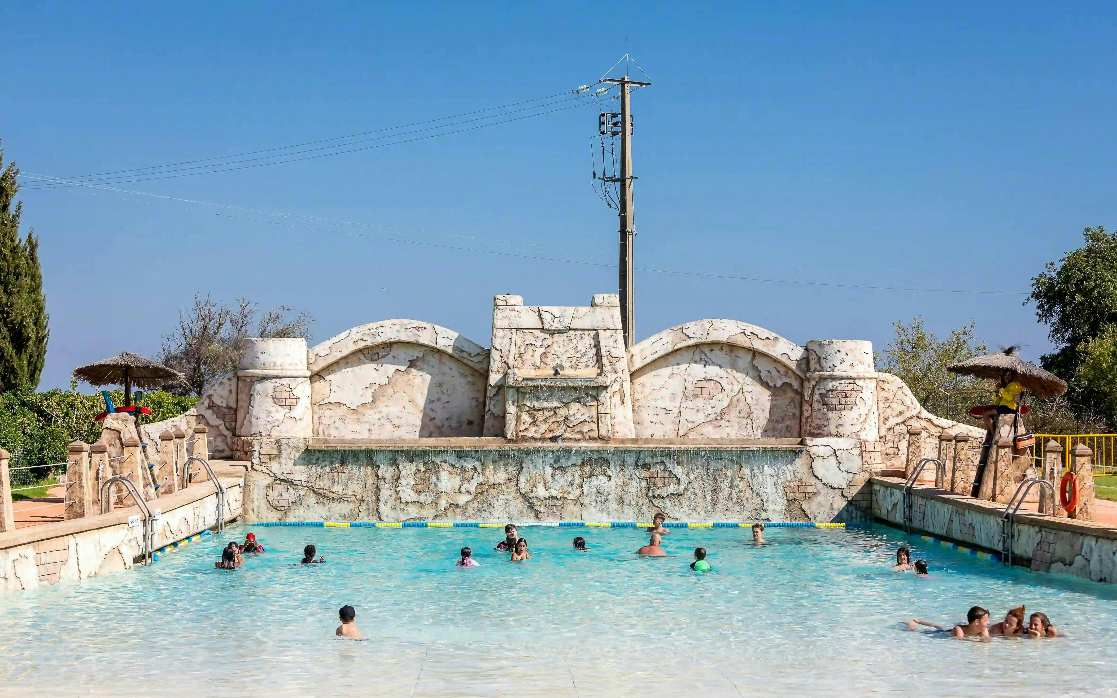Visitors enjoying the pool at Aqualand Algarve's surf beach.