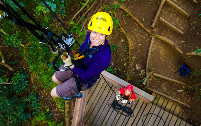 Guest ziplining on Kohala Canopy Adventure in Hawaii forest.