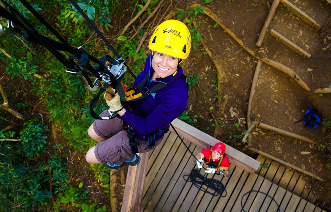 Guest ziplining on Kohala Canopy Adventure in Hawaii forest.