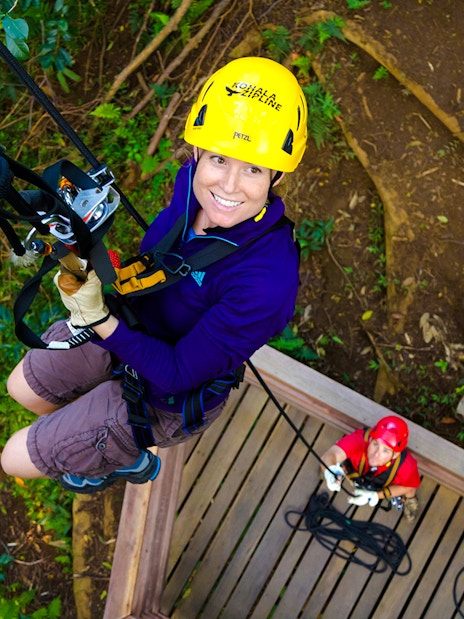 Guest ziplining on Kohala Canopy Adventure in Hawaii forest.