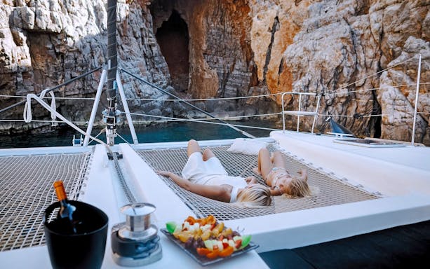 Lounging on catamaran nets near Barbarossa Cave, Spinalonga, Crete.