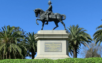 Equestrian statue of the Marquis of Linlithgow in Melbourne, surrounded by palm trees.