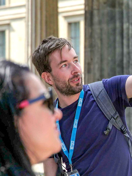 Guide explaining history during Berlin World War II walking tour.