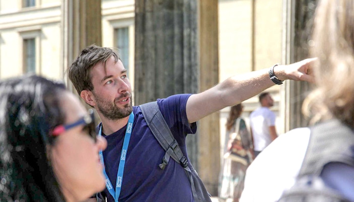 Guide explaining history during Berlin World War II walking tour.
