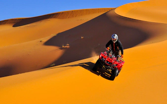 Quad biking on sand dunes during Dubai Desert Safari.