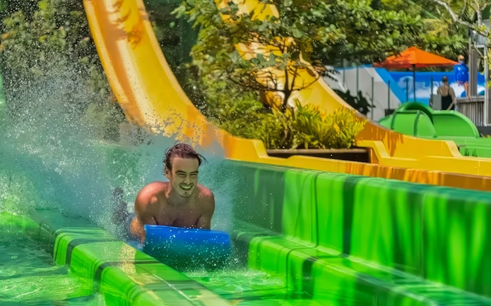 Man sliding down a water slide at Waterbom Bali, Indonesia.