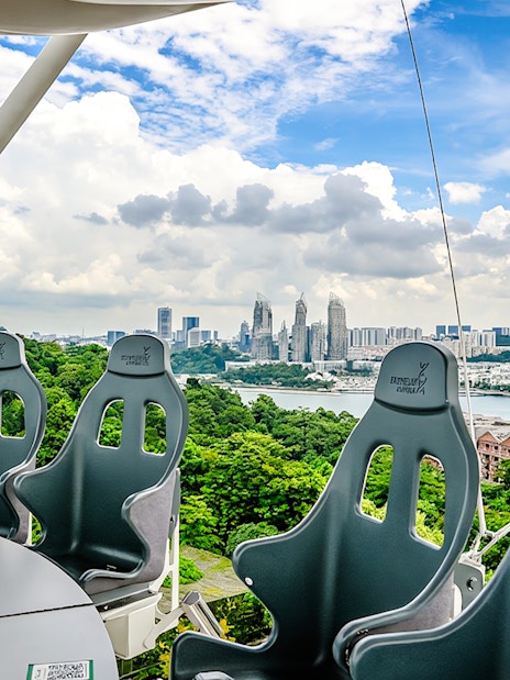 Skyhelix Sentosa ride with panoramic view of Singapore skyline and lush greenery.