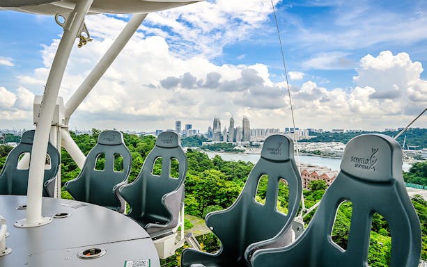 Skyhelix Sentosa ride with panoramic view of Singapore skyline and lush greenery.
