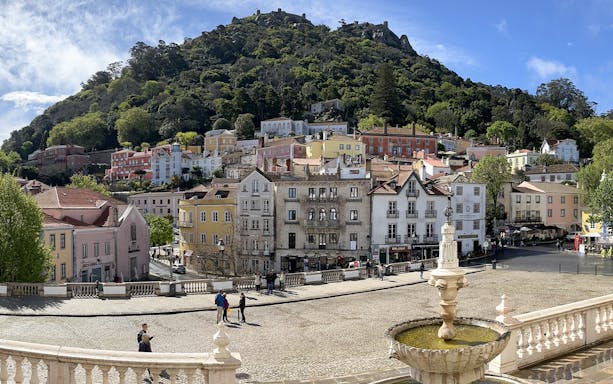 Sintra town square with colorful buildings and lush hillside in Portugal.