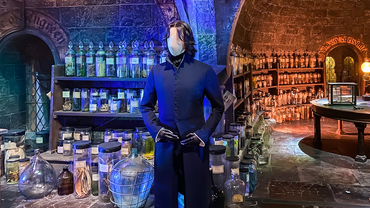 Visitors exploring costume exhibit at Harry Potter London tours, featuring iconic wizard robes and props.