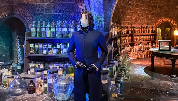 Visitors exploring costume exhibit at Harry Potter London tours, featuring iconic wizard robes and props.