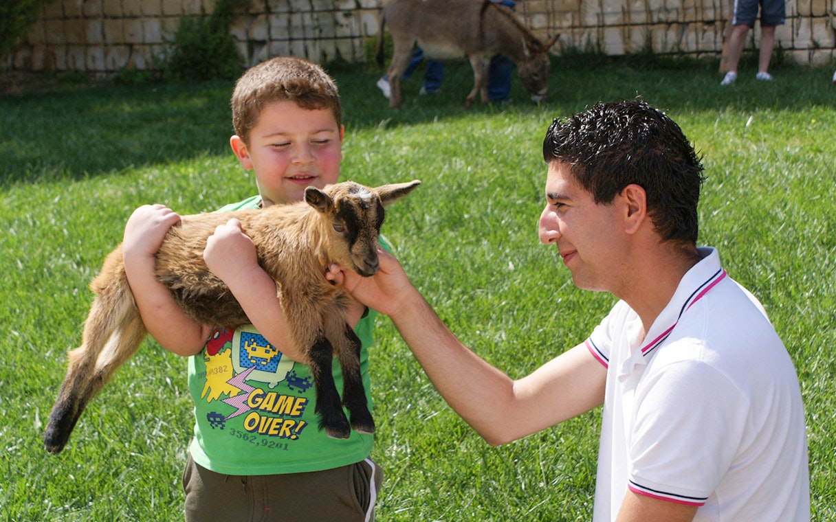Child holding a goat at Limestone Heritage Park & Gardens, Malta.