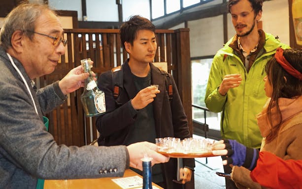Visitors tasting sake at a Kyoto brewery during a guided walking tour.