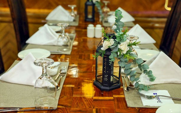 Elegant table setting on Dubai Marina Dhow Cruise with floral centerpiece and dinnerware.