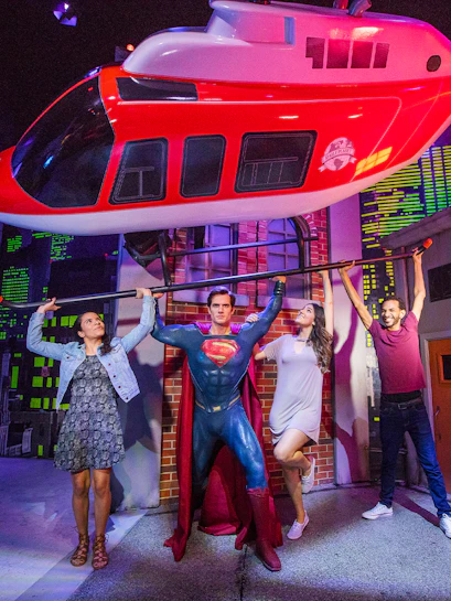 Superman figure lifting helicopter with visitors at Madame Tussauds Orlando.