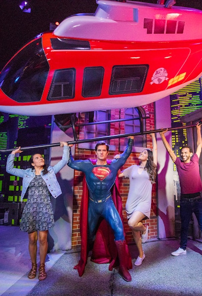Superman figure lifting helicopter with visitors at Madame Tussauds Orlando.