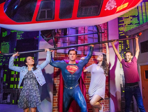Superman figure lifting helicopter with visitors at Madame Tussauds Orlando.