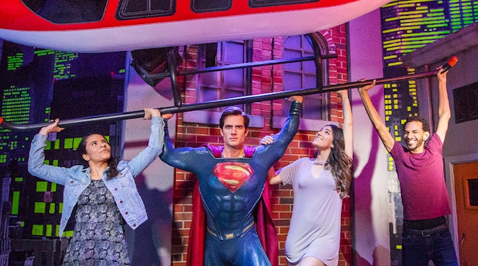 Superman figure lifting helicopter with visitors at Madame Tussauds Orlando.