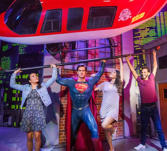 Superman figure lifting helicopter with visitors at Madame Tussauds Orlando.